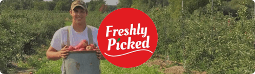 Photo of a farmer in an apple orchard owned by Freshly Picked, a small business using SlickText to reach customers